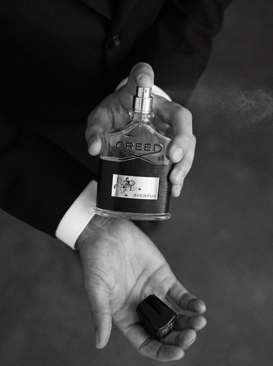 Hands holding a perfume bottle, black and white